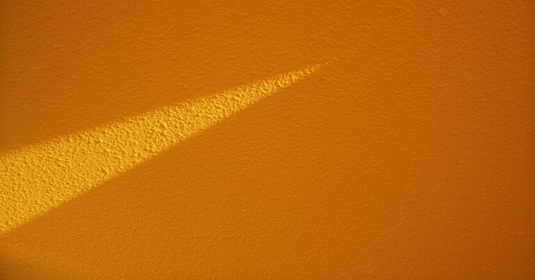A hard line of light falling across a warm wall