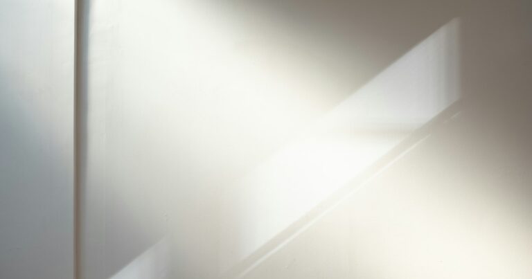 Soft sunlight falling in a diagonal band across a pale wall