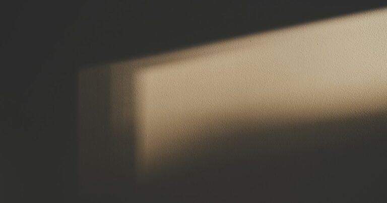 A soft band of window light across a quiet plain wall