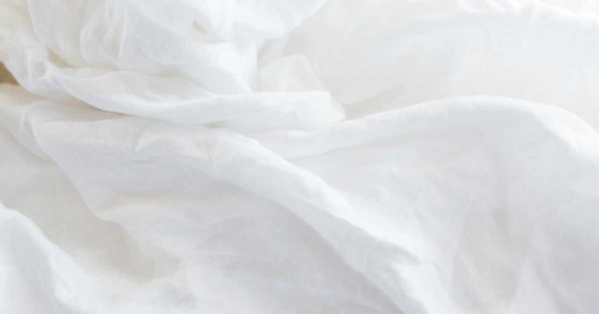 White linen in soft folds lit by early morning light